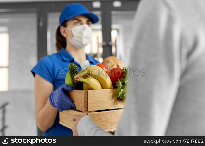 health protection, safety and pandemic concept - delivery woman in face mask and gloves giving wooden box with food to female customer. delivery woman in mask giving food to customer