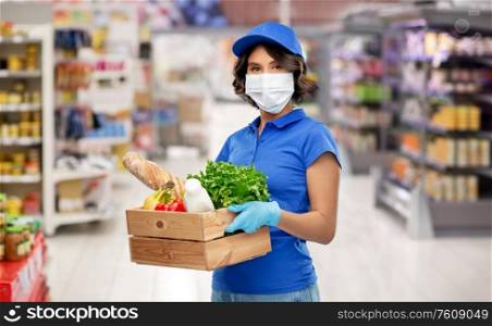 health protection, safety and pandemic concept - delivery woman in face protective medical mask and gloves holding wooden box with food over supermarket or grocery store background. delivery girl in mask with food in box at store