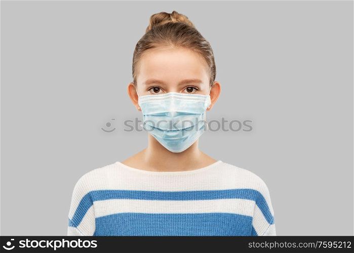 health protection, safety and pandemic concept - teenage girl in protective medical mask over grey background. teenage girl in protective medical mask