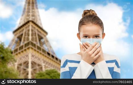 health protection, safety and pandemic concept - teenage girl in protective medical mask over grey background. teenage girl in protective medical mask in france