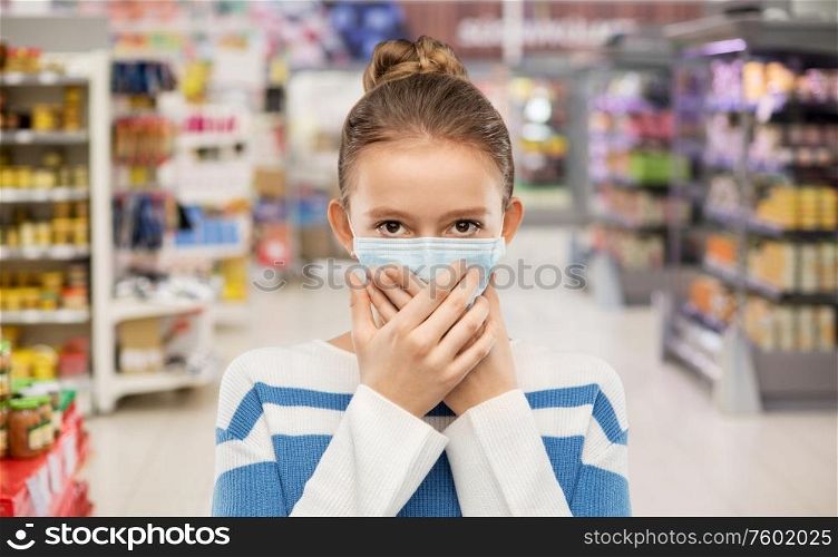 health protection, safety and pandemic concept - teenage girl in protective medical mask over supermarket background. teenage girl in medical mask at supermarket