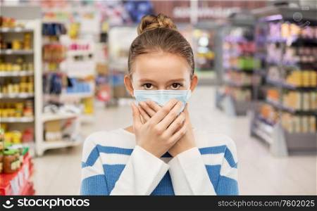 health protection, safety and pandemic concept - teenage girl in protective medical mask over supermarket background. teenage girl in medical mask at supermarket
