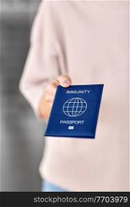 health protection, vaccination and pandemic concept - close up of woman holding immunity passport. close up of woman holding immunity passport