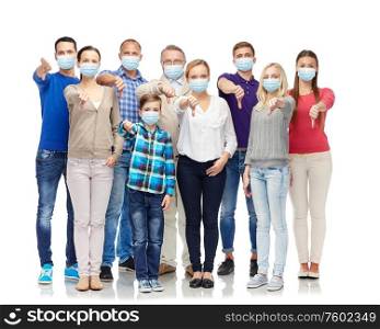 health, quarantine and pandemic concept - group of people wearing protective medical masks for protection from virus showing thumbs down. people in medical masks showing thumbs down