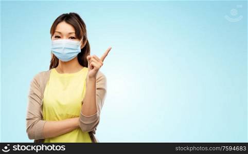 health, safety and pandemic concept - asian young woman wearing protective medical mask for protection from virus disease over blue background. asian young woman in protective medical mask