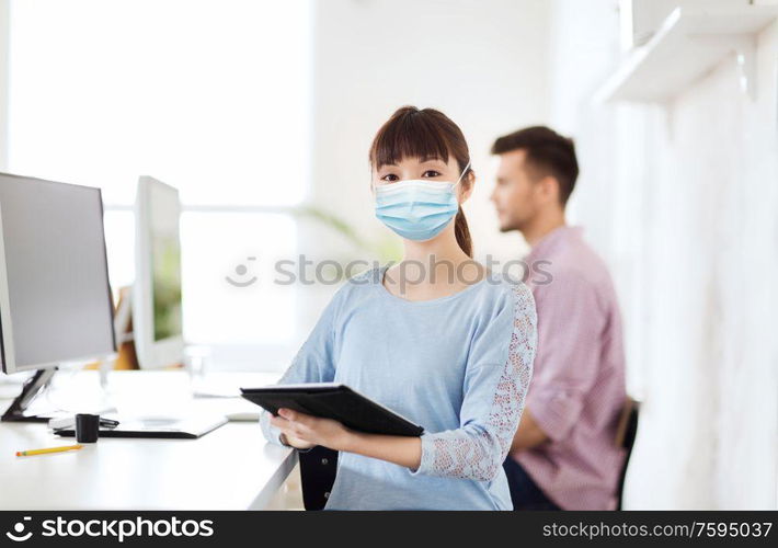 health, safety and pandemic concept - asian young woman wearing protective medical mask for protection from virus disease at office. asian woman in protective medical mask at office