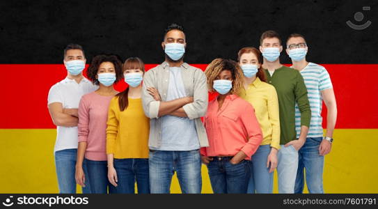 health, safety and pandemic concept - group of people wearing protective medical masks for protection from virus over german flag background. people in medical masks for protection from virus