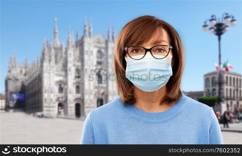 health, safety and pandemic concept - portrait of senior woman in glasses wearing protective medical mask for protection from virus over milano cathedral in rome, italy background. senior woman in protective medical mask in italy