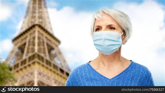 health, safety and pandemic concept - portrait of senior woman wearing protective medical mask for protection from virus over eiffel tower in paris, france background. senior woman in protective medical mask in france