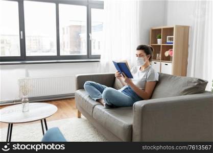 health, safety and pandemic concept - sick young woman in protective medical mask reading book at home. sick woman in medical mask reading book at home