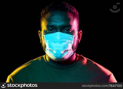 health, safety and pandemic concept - young african american man wearing protective medical mask over black background. african american man wearing medical mask