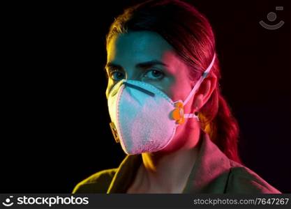 health, safety and pandemic concept - young woman wearing protective mask or respirator over black background. young woman wearing protective mask or respirator