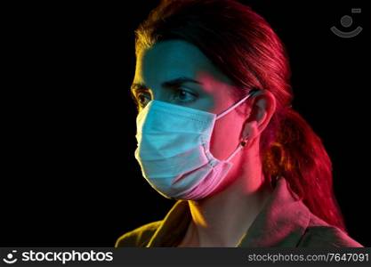 health, safety and pandemic concept - young woman wearing protective medical mask over black background. young woman wearing protective medical mask