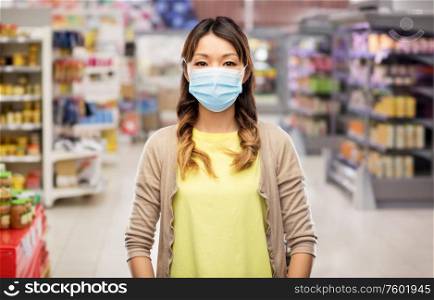 health safety, quarantine and pandemic concept - asian young woman wearing protective medical mask for protection from virus disease over blue background. asian young woman in protective medical mask