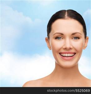 health, spa and beauty concept - clean face of beautiful young laughing woman