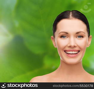 health, spa and beauty concept - clean face of beautiful young laughing woman