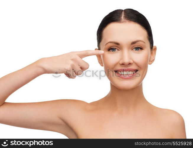 health, spa and beauty concept - clean face of beautiful young woman pointing to her eye