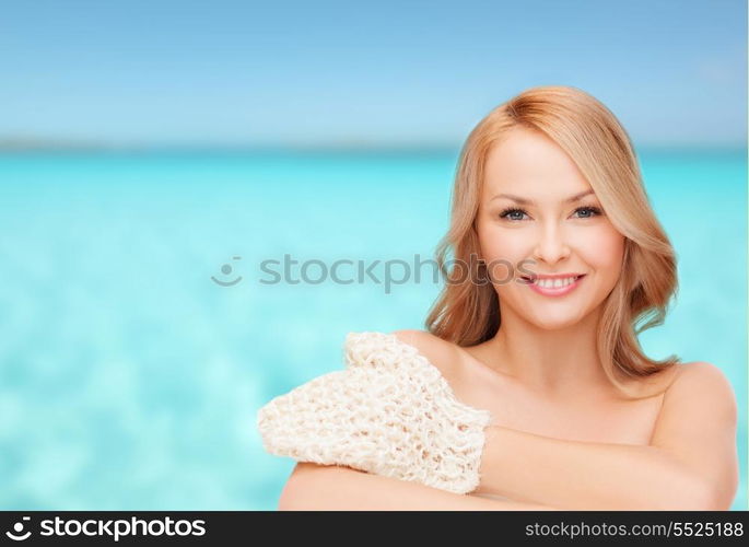 health, spa and beauty concept - smiling woman with exfoliation glove