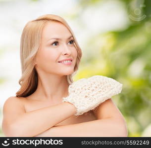 health, spa and beauty concept - smiling woman with exfoliation glove