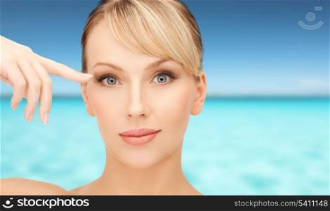 health, spa, beauty and vacation concept - face of beautiful woman touching her eye area