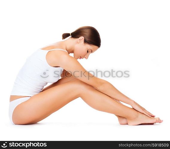 health, sport and beauty concept - sporty woman in cotton underwear doing exercises
