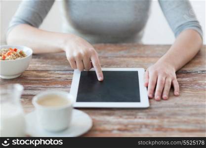 health, technology, internet, food and home concept - close up of woman pointing finger to tablet pc computer screen