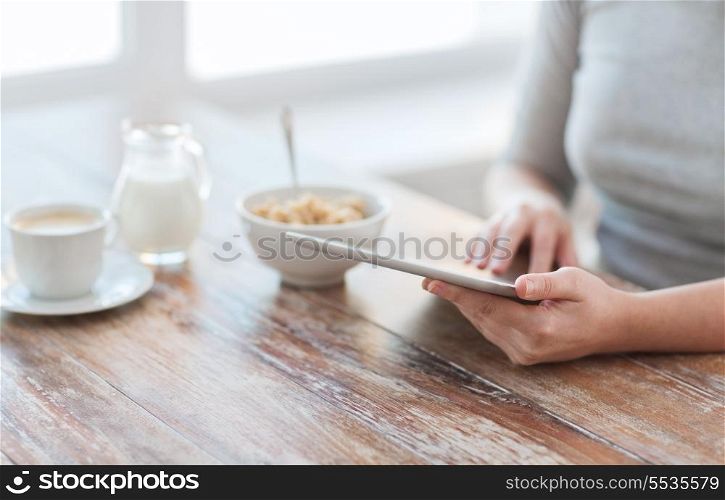 health, technology, internet, food and home concept - close up of woman reading morning news from tablet pc computer