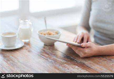 health, technology, internet, food and home concept - close up of woman reading morning news from tablet pc computer