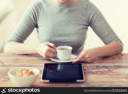 health, technology, internet, food and home concept - close up of woman drinking coffee and using tablet pc computer