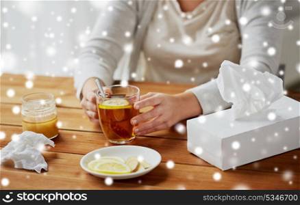 health, traditional medicine and ethnoscience concept - close up of ill ill woman drinking tea with lemon over snow. close up of ill woman drinking tea with lemon