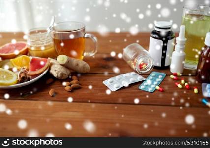 health, traditional medicine and ethnoscience concept - natural and synthetic drugs on wooden table over snow. traditional medicine and synthetic drugs