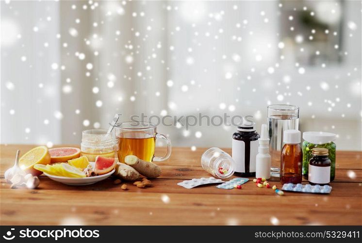 health, traditional medicine and ethnoscience concept - natural and synthetic drugs on wooden table over snow. traditional medicine and synthetic drugs