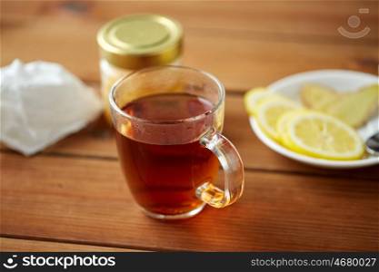 health, traditional medicine, folk remedy and ethnoscience concept - tea cup with lemon and honey
