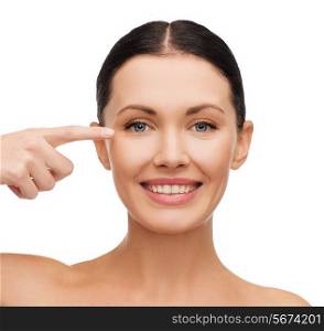 health, vision and beauty concept - young smiling woman pointing to her eye
