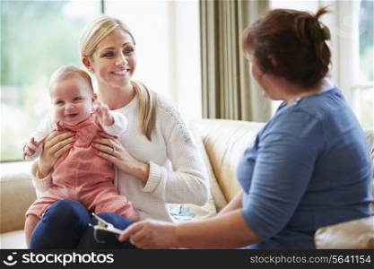 Health Visitor Talking To Mother With Young Baby