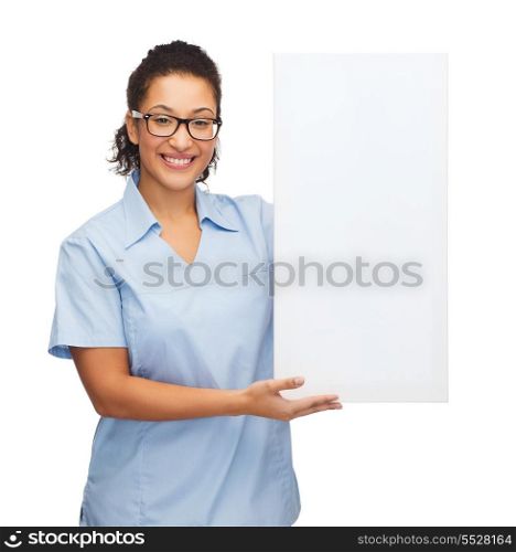 healthcare, advertisement and medicine concept - smiling female african american doctor or nurse in eyeglasses with small white blank board