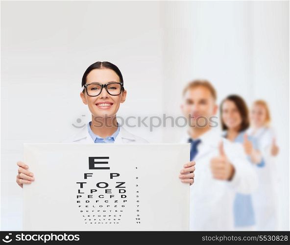 healthcare, advertisement and medicine concept - smiling female doctor in eyeglasses with eye chart