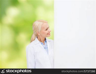healthcare, advertisement, people and medicine concept - smiling female doctor looking to white blank board over green background