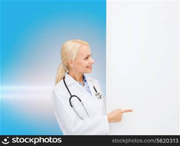 healthcare, advertisement, people and medicine concept - smiling female doctor with stethoscope showing something over blue background
