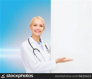 healthcare, advertisement, people and medicine concept - smiling female doctor with stethoscope showing something over blue background