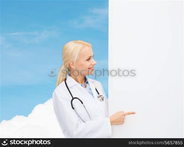 healthcare, advertisement, people and medicine concept - smiling female doctor with stethoscope showing something over blue sky background