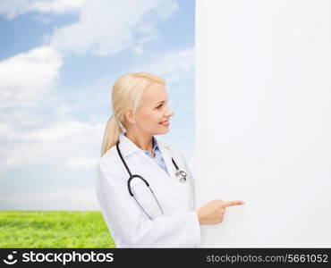 healthcare, advertisement, people and medicine concept - smiling female doctor with stethoscope showing something over natural background