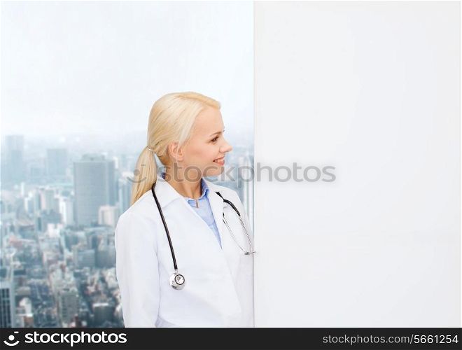 healthcare, advertisement, people and medicine concept - smiling female doctor with stethoscope looking at something over city background