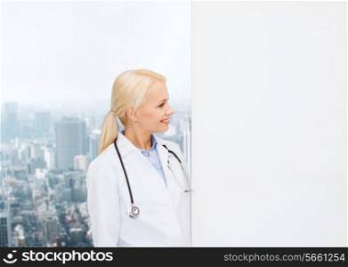 healthcare, advertisement, people and medicine concept - smiling female doctor with stethoscope looking at something over city background