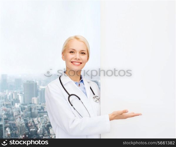 healthcare, advertisement, people and medicine concept - smiling female doctor with stethoscope showing something over city background