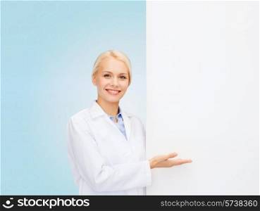 healthcare, advertisement, people and medicine concept - smiling female doctor with white blank board over blue background
