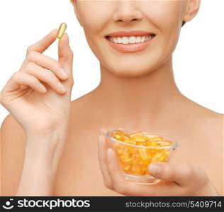 healthcare and beauty concept - beautiful woman with omega 3 vitamins