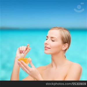 healthcare and beauty concept - lovely woman with omega 3 vitamins