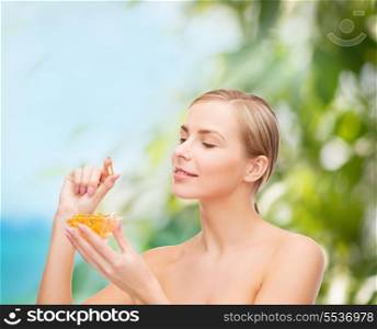 healthcare and beauty concept - lovely woman with omega 3 vitamins
