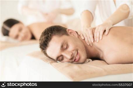 healthcare and beauty concept - picture of couple in spa salon getting massage